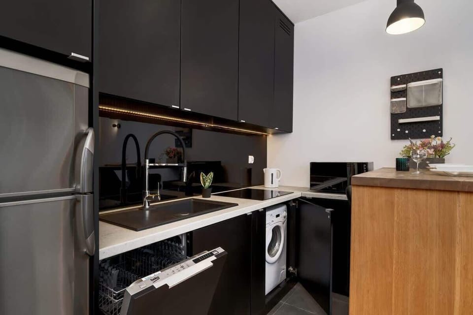 Another angle of the kitchen, showcasing sleek black cabinets, built-in appliances, and a well-organized space.

