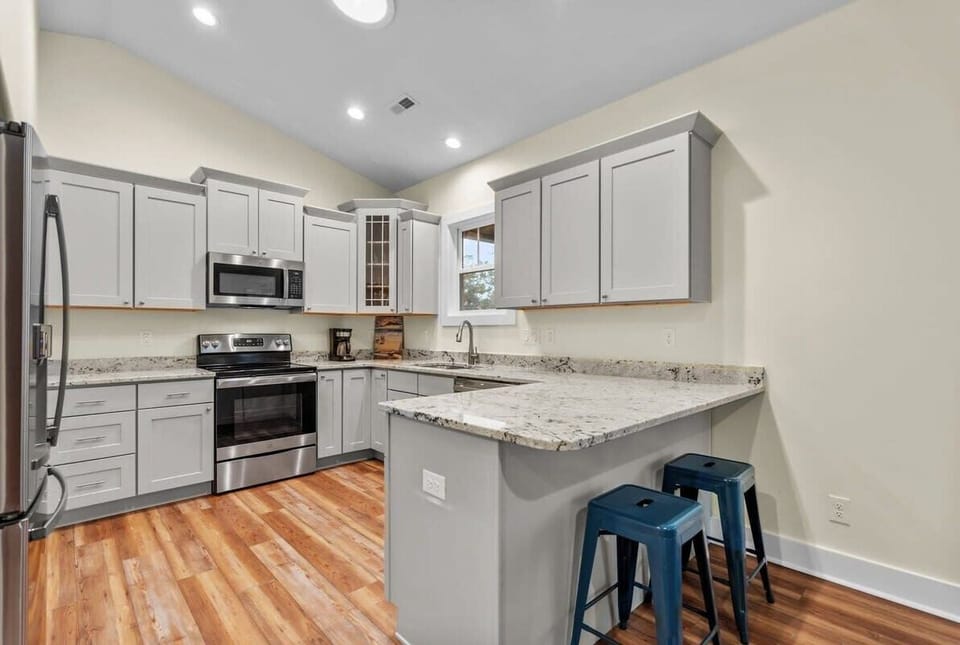 Fully Equipped Kitchen w/ Refrigerator, Oven, Stove, Sink, Dishwasher, Cooking Utensils, and Bar Seating Area