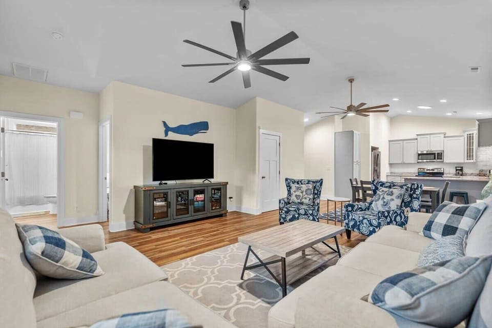 Spacious Open-Concept Living Area w/ Sectional Sofa, Accent Chairs, Coffee Table, Smart TV, Ceiling Fan, and Kitchen w/ Breakfast Bar Seating