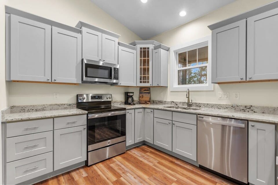 Fully Equipped Kitchen w/ Refrigerator, Oven, Stove, Sink, Dishwasher, Cooking Utensils, and Bar Seating Area
