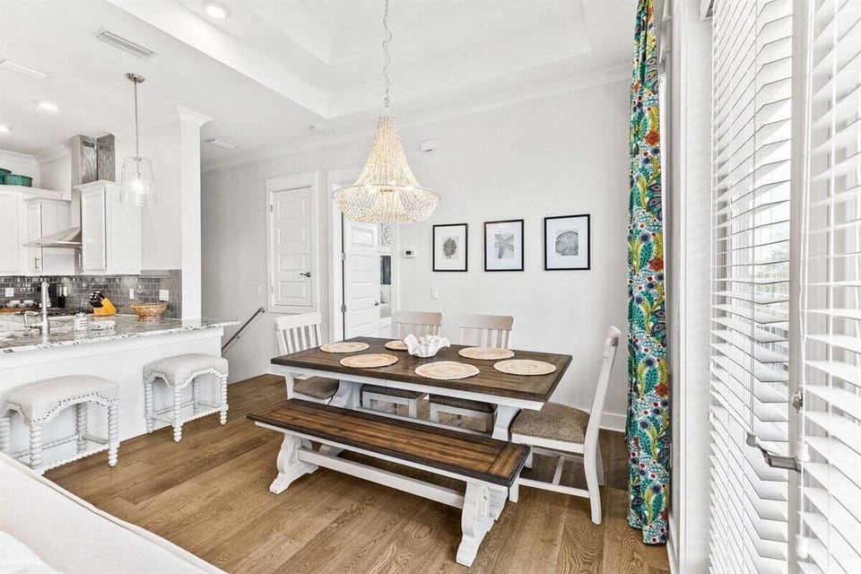 Enjoy a delicious meal under a stunning chandelier in this stylish dining space.