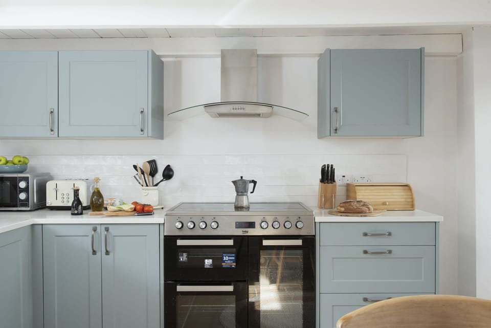 The kitchen with a stove top, oven and tea facilities - School Cottage