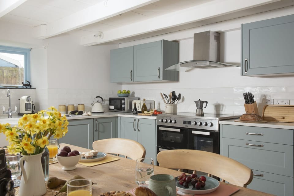 The kitchen with a stove top, oven and tea facilities - School Cottage