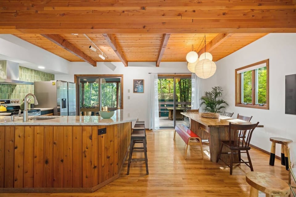 Dining room and kitchen w/view of screened porch and patio/firepit table