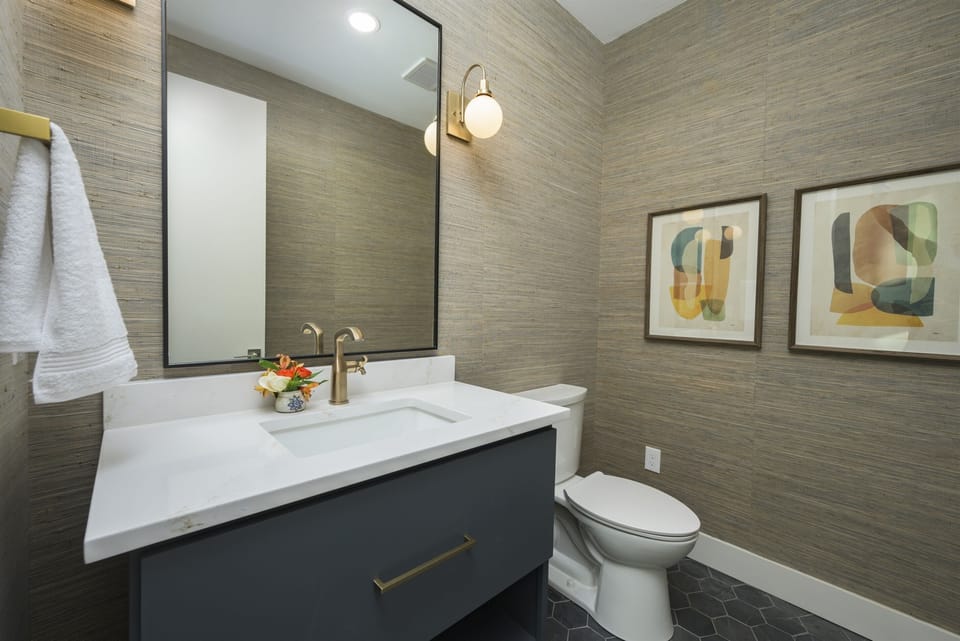 Half Bath Oasis: Enjoy stylish design with gold accents and modern art for a refreshing retreat!