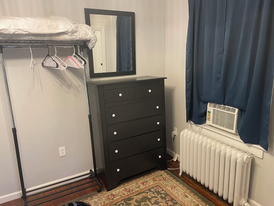 Dresser and extra hanging rack with extra blanket and pillow. Blackout curtains.