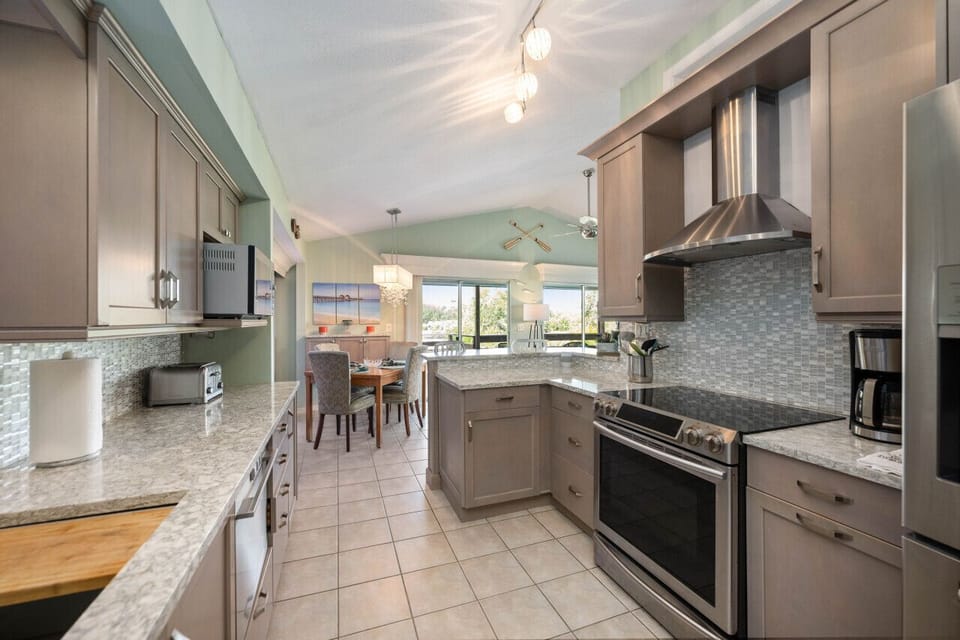 Fully equipped kitchen offering granite counters and a breakfast bar.