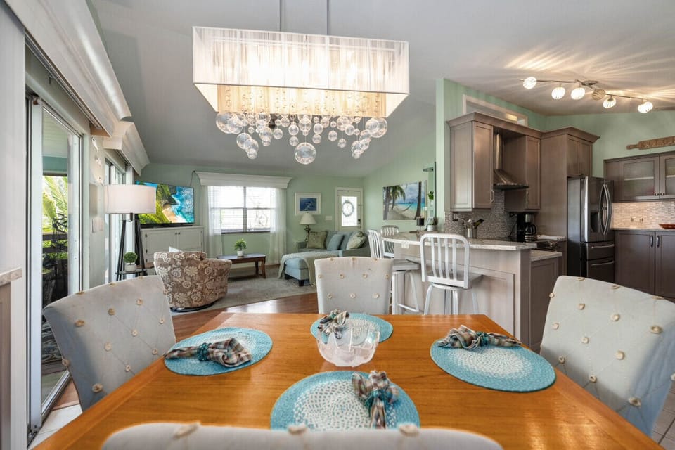 Stylish wooden table offering comfortable seating under a modern chandelier.