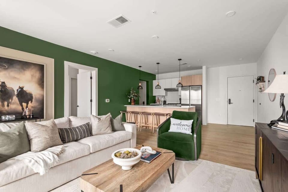 Living room with couch seating and accent chair looking out to the kitchen