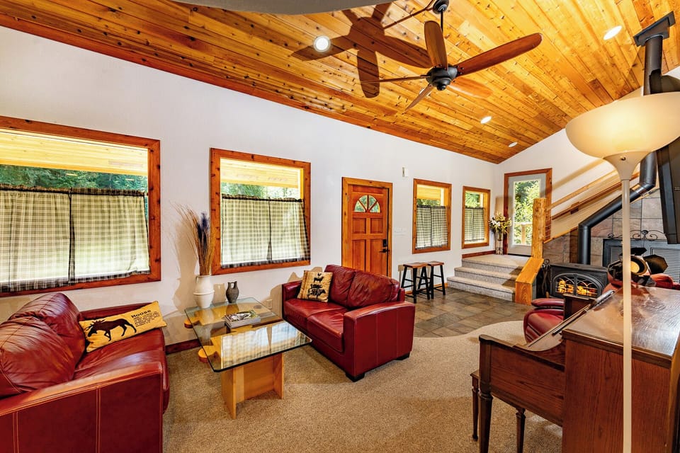 Airy summer cabin living room with forest views near Silverwood Theme Park.