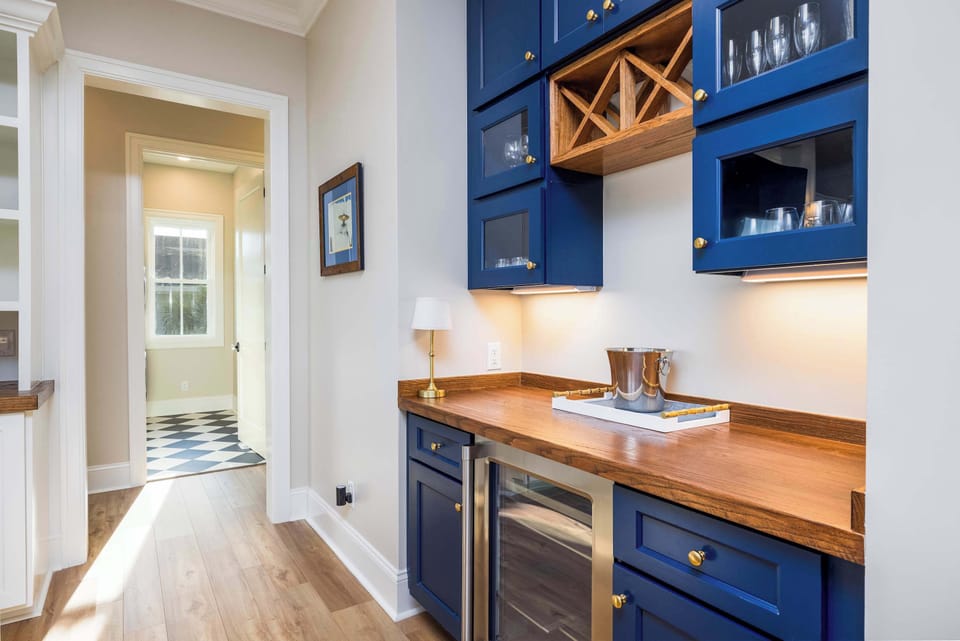Bar with Wine Cooler and Hallway to Laundry/Primary Bedrooms