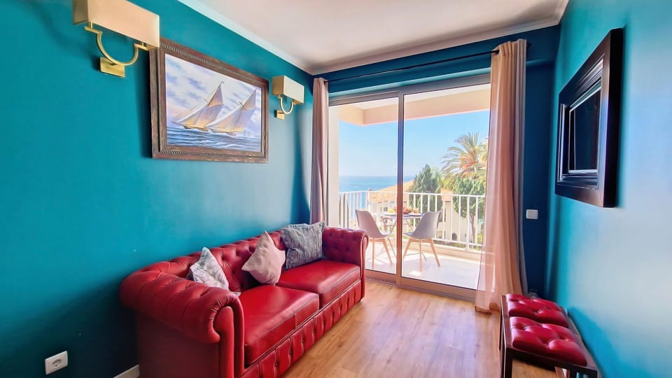 Inviting living room in quaint T1 apartment boasting a scenic ocean-view balcony, perfect for relaxation. #funchal #oceanview #vistamar