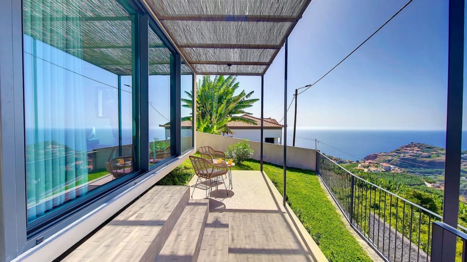Charming house facade with a breakfast table, offering breathtaking ocean and mountain vistas. #oceanview #outdoorfurniture #mountainview #housefacade