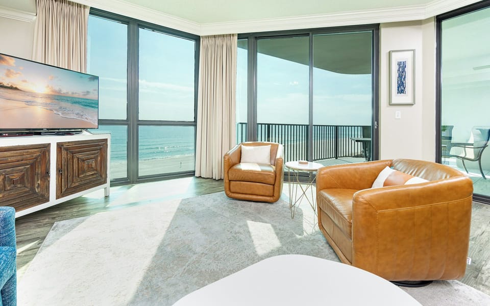 Your living room invites you to sink into soft leather chairs while the gulf coast sparkles beyond the balcony