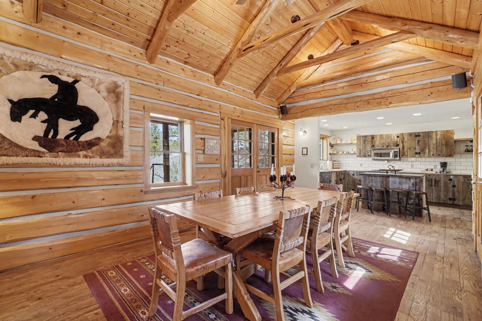 Gather around this stunning log dining table where warm wood beams create the perfect rustic atmosphere for your memorable meals together.