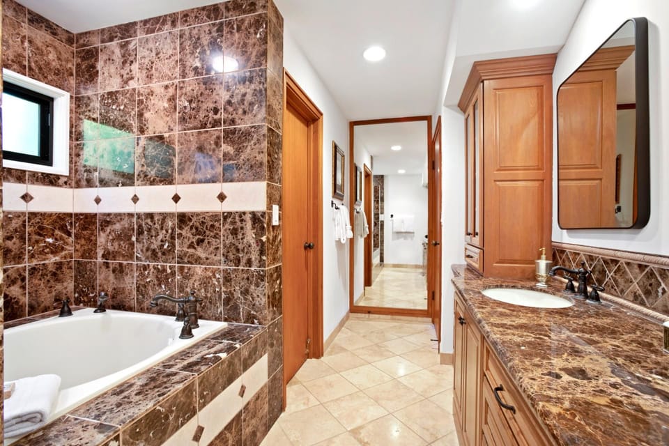 Luxurious bathroom with marble finishes, soaking tub, and double vanity.