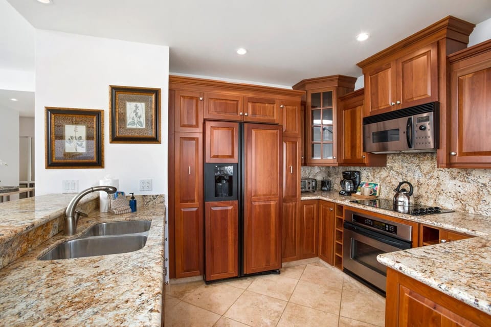Warm wood cabinetry and granite surfaces define this elegant kitchen.