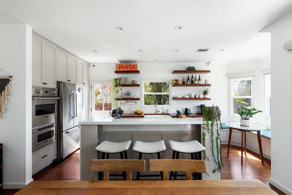 A stylish and well-equipped kitchen with open shelving, modern finishes, and additional bar seating for casual meals and effortless entertaining.