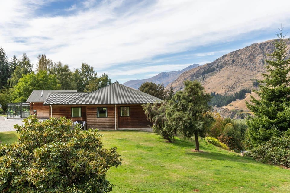 Exterior Retreat: Scenic views and inviting greenery surround this charming getaway in Queenstown!