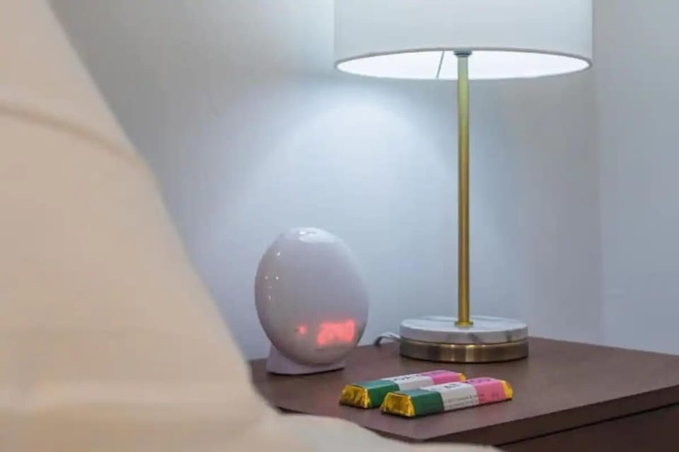 
A bedside scene with a chic lamp and colorful accents, providing a peaceful and stylish atmosphere.