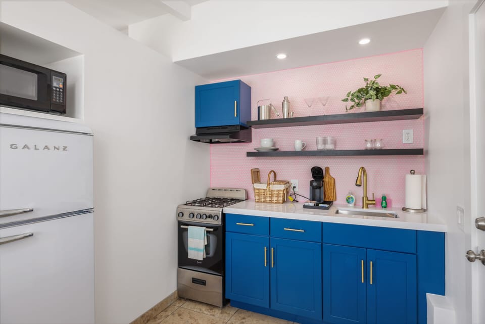 Cook in style in the Barbie Suite kitchen with vibrant blue cabinetry and sleek appliances—perfect for culinary adventures in the desert.