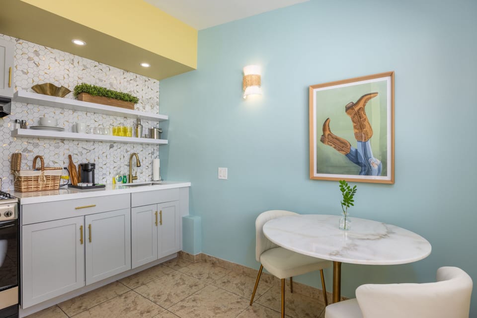 Enjoy a fully equipped kitchenette with open shelving, modern finishes, and a touch of Palm Springs charm.