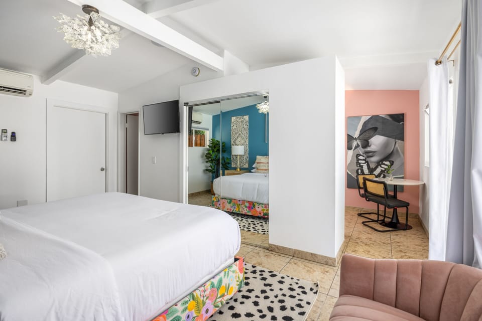 Unwind in this spacious Palm Springs bedroom with a plush king bed, cozy sitting area, and retro flair. Your perfect boutique desert retreat awaits.