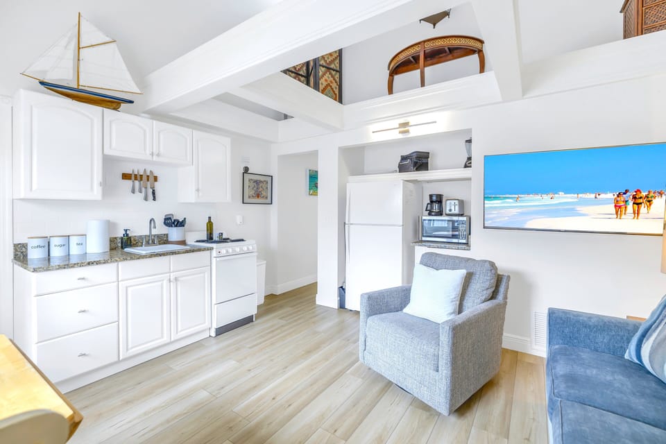 Bright one-bedroom unit featuring a full kitchen and cozy living space, perfect for a beach getaway.