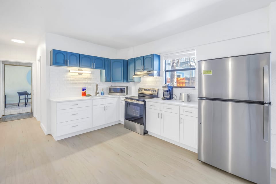 Bright kitchen with stainless steel appliances, cookware, and dining essentials in Siesta Key 2BR.