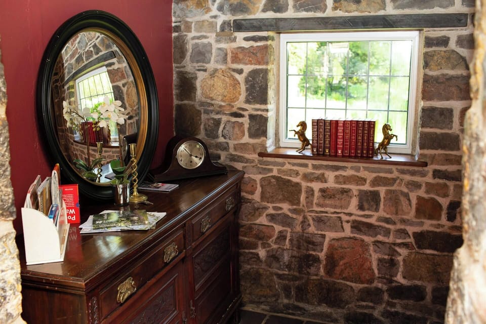 sideboard with round mirror and welcome pack with leaflets, books on window sill