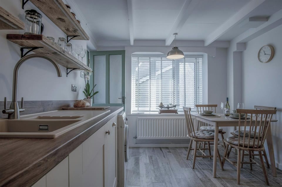 kitchen view facing window and wooden dining set