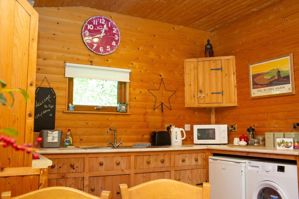 wood panelling kitchen, washing machine and under counter fridge, wall art of star