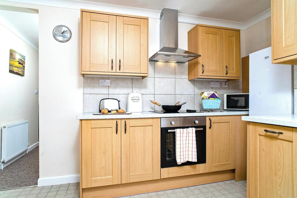 Kitchen with oven and hob, fridge freezer, microwave and toaster