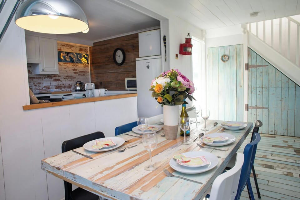 Rustic dining area with long table, place settings, and mixed chairs