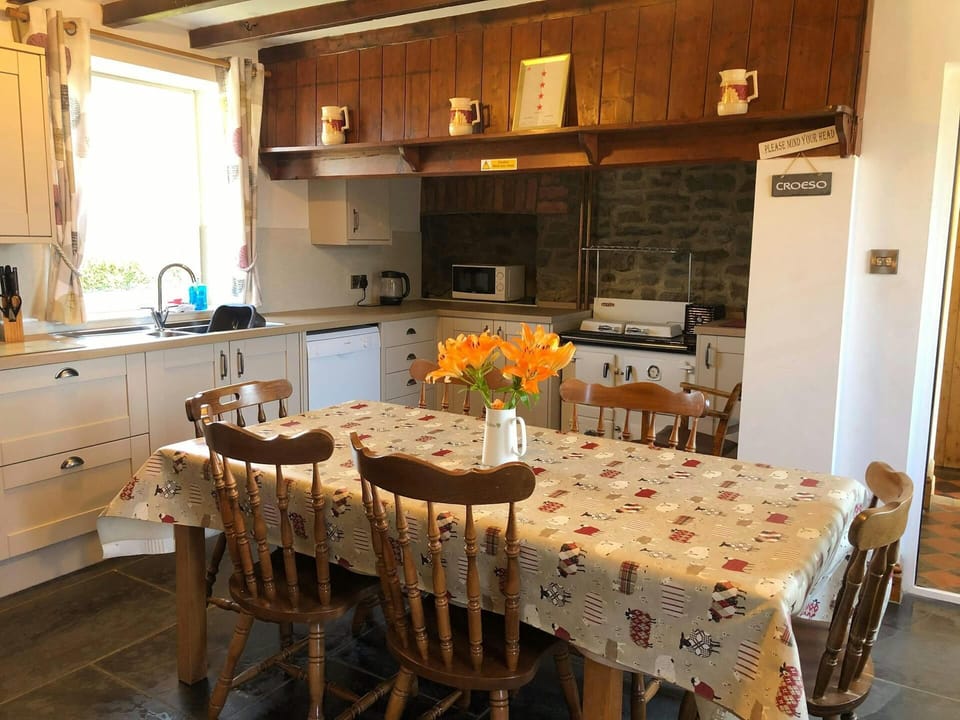 Kitchen with dining table and six chairs, range cooker, dishwasher, microwave and kettle