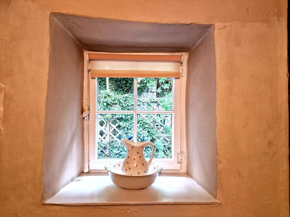 Small window and windowsill with bowl and jug