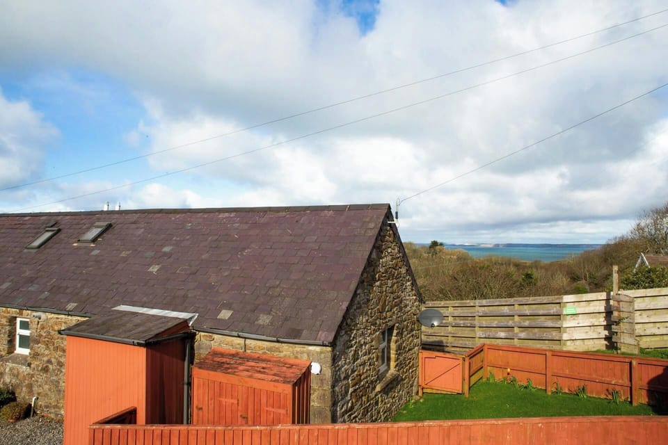 Outside view of Bay Cottage with distant sea and countryside