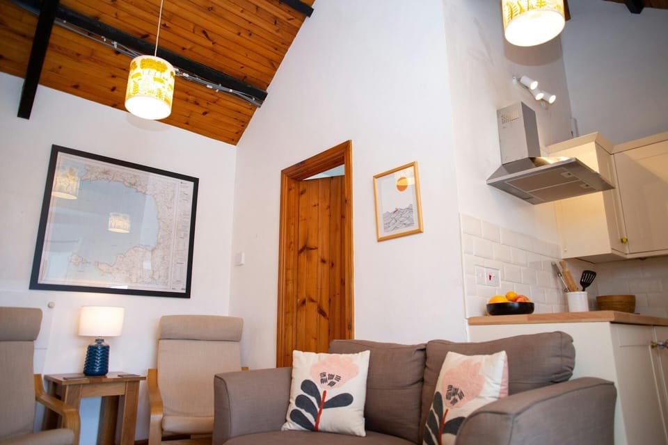 Lounge area with sofa and two armchairs, side table and lamp