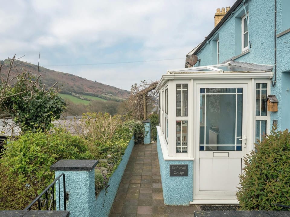 Conservatory at the rear of Driftwood Cottage with paved terrace and valley views