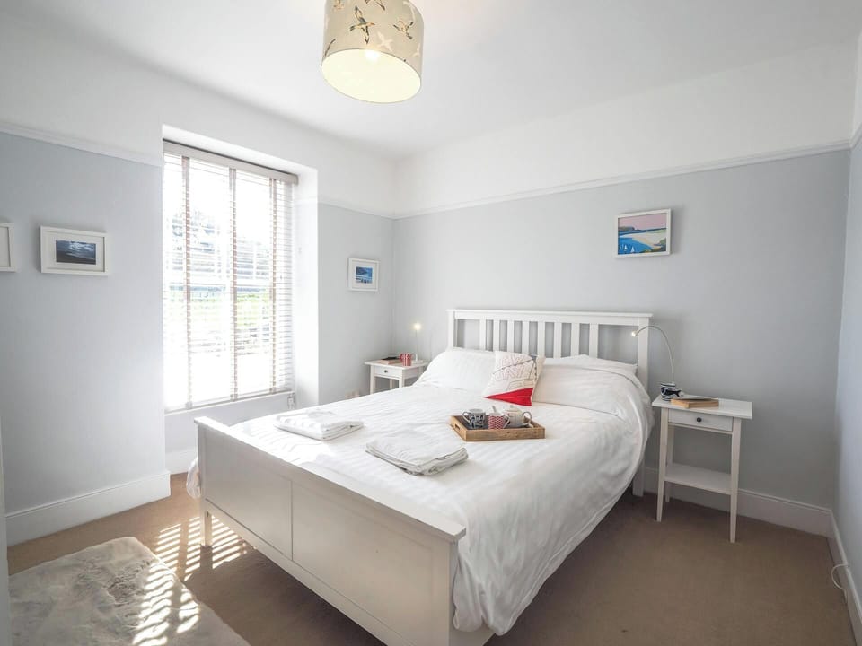 Double bed, bedside tables with lamps and large window with blinds