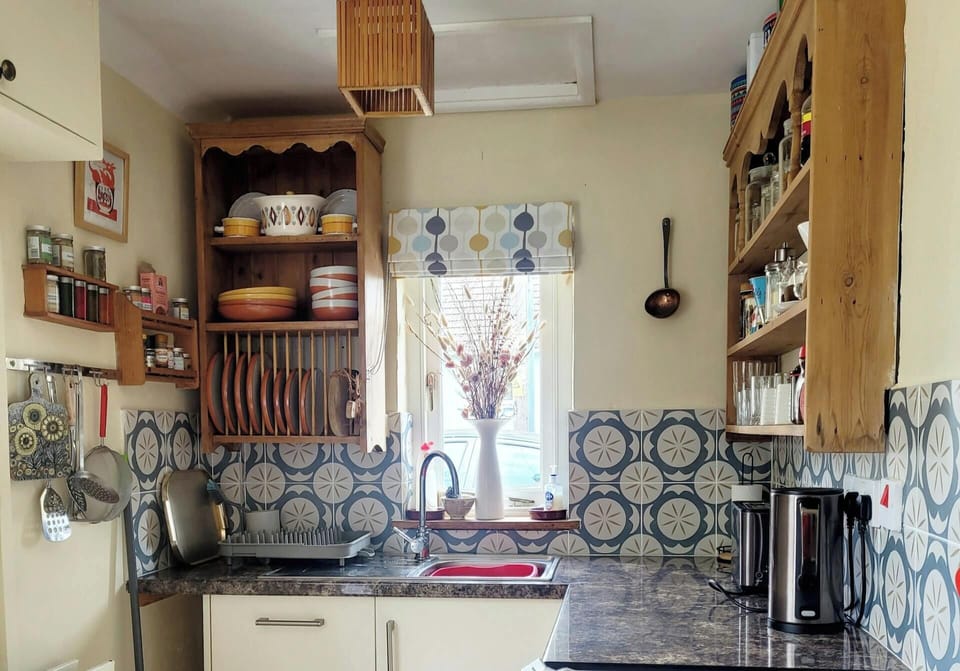 Fitted kitchen with wooden shelves and plate rack