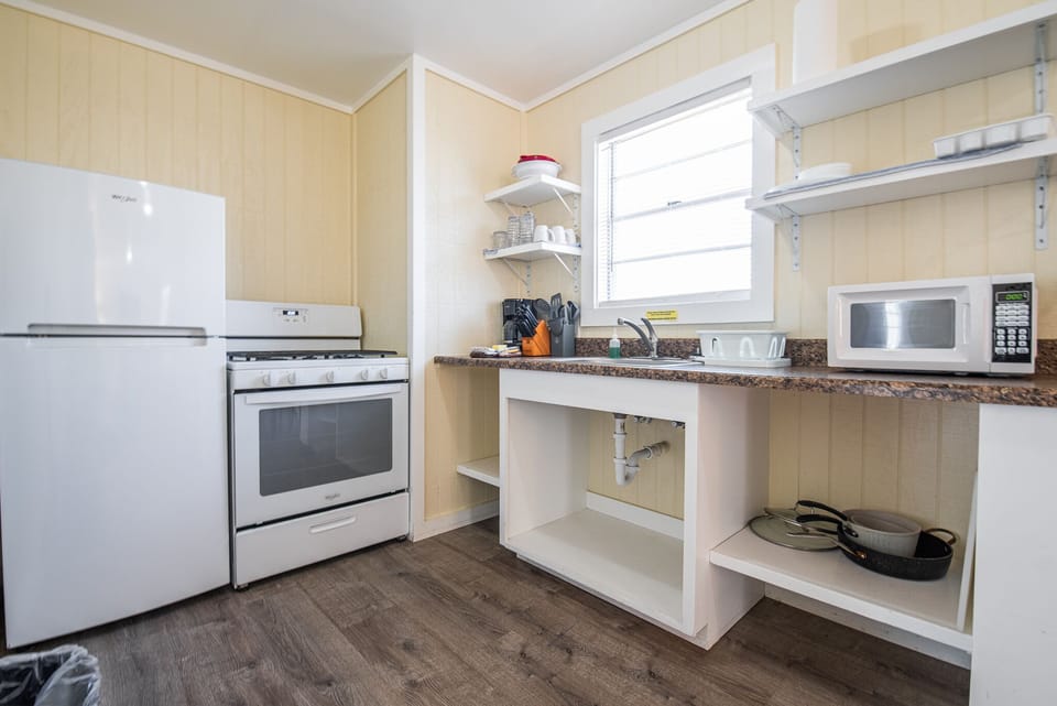 The kitchenette has a refrigerator, gas range, coffee maker, and microwave