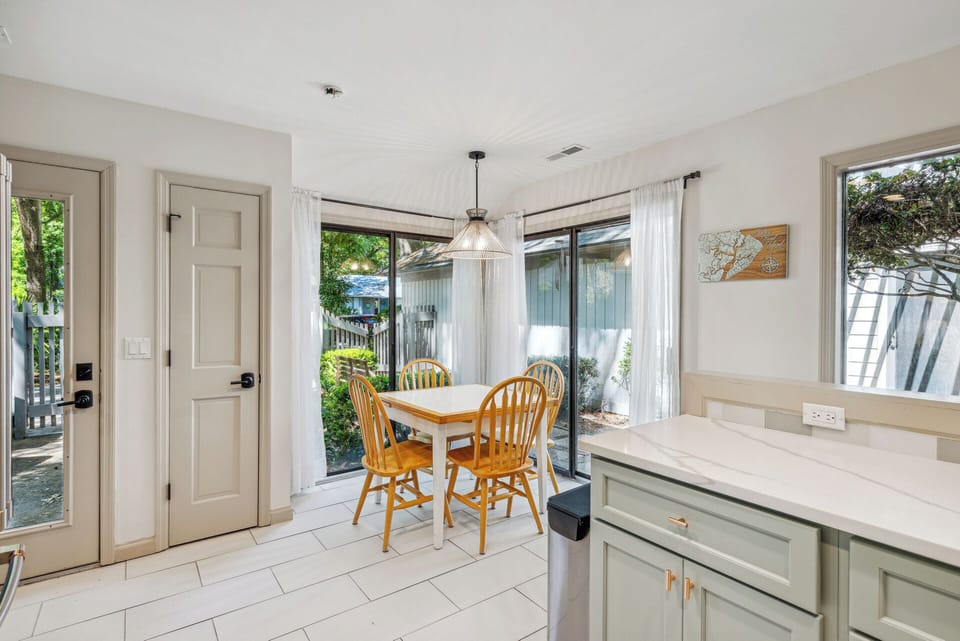 Fully stocked gourmet kitchen with stainless steel appliances, gas stove, Keurig, drip coffee maker and dining area with a courtyard view.
