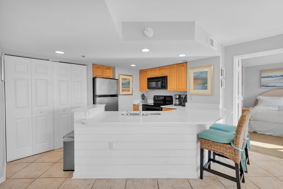 Fully stocked kitchen with 2 barstools.