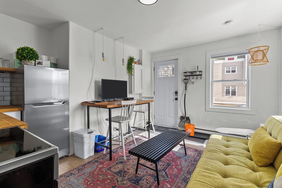 Bright and cozy living space with a work desk, stylish seating, and natural light.