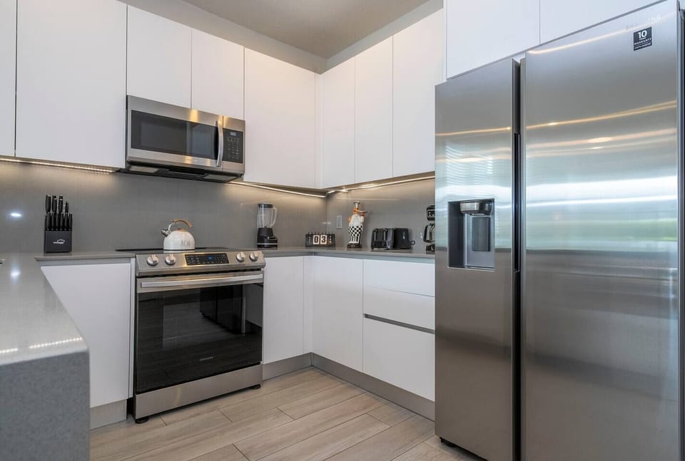 The fully equipped kitchen features modern appliances, sleek cabinetry, and all essential cookware and utensils, making it perfect for preparing meals with ease.