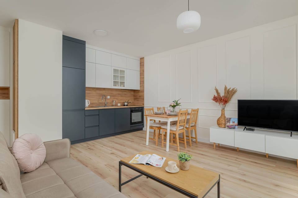 A view of the kitchen and living space from a different perspective, highlighting the modern design and harmonious flow between the two areas. The use of light wood and neutral colors adds warmth and comfort to the space.