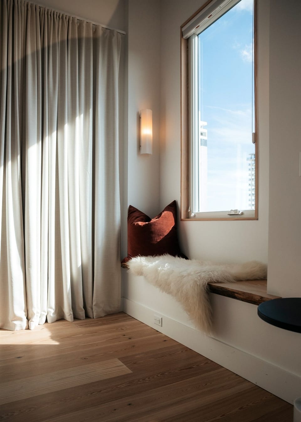 Sunlit window bench with warm wood accents — a cozy corner designed for slowing down.