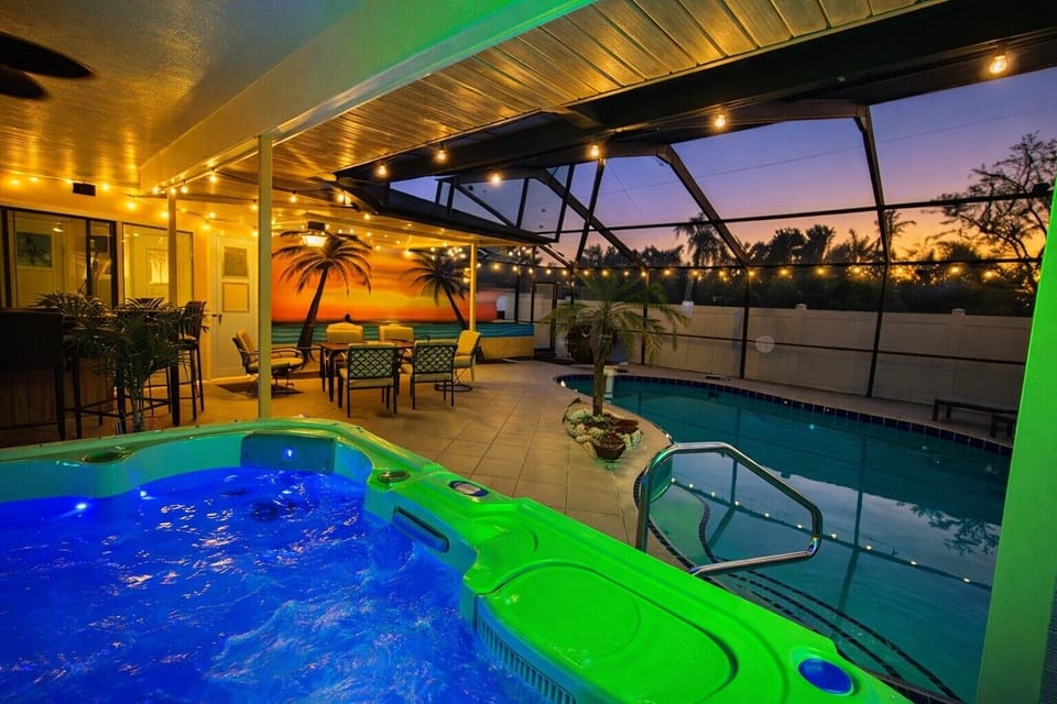 Sink into the green-lit hot tub after dark, string lights glowing overhead on the screened lanai.