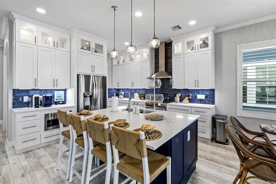 Sleek kitchen with blue accents, modern finishes, and ample seating for dining!